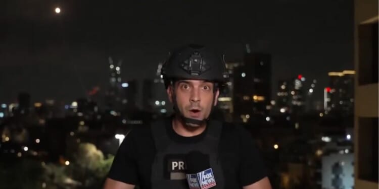 During a live report from Tel Aviv, Israel, on Tuesday, Fox News correspondent Trey Yingst had to run for cover as Iranian missiles appeared in the sky behind him.