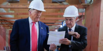 President Donald Trump, left, hands a paper to Federal Reserve Chair Jerome Powell, right, as they tour the Federal Reserve’s $2.5 billion headquarters renovation project in Washington, D.C., on Thursday.