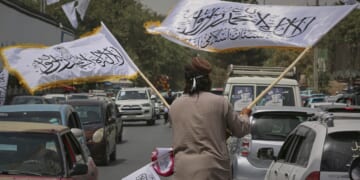 A man waves Taliban flags for sale on Thursday, ahead of celebrations marking the fourth anniversary of the U.S. withdrawal from Afghanistan and the start of Taliban rule in Kabul.