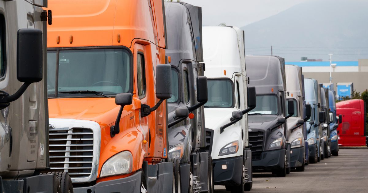 Semi-trucks are parked in a row near the Otay Mesa Port of Entry in San Diego, California.