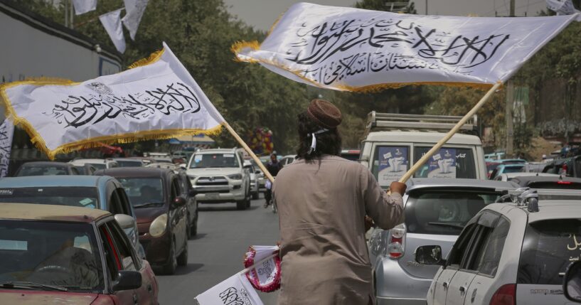 A man waves Taliban flags for sale on Thursday, ahead of celebrations marking the fourth anniversary of the U.S. withdrawal from Afghanistan and the start of Taliban rule in Kabul.