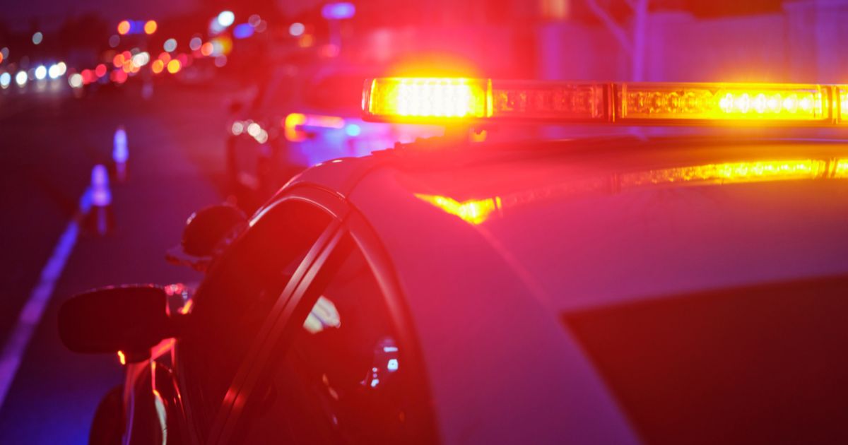 A police car flashes its lights at night.