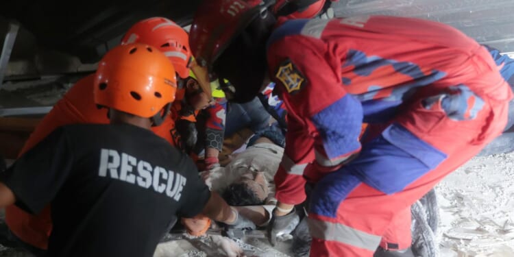 Indonesia school collapse: Rescuers run oxygen to survivors that buried dozens