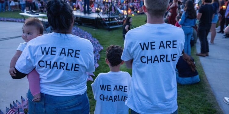 People wear shirts reading "we are Charlie" as they pay their respects to the late Charlie Kirk at a vigil in Provo, Utah, on Sept. 12, 2025.