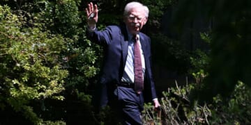 John Bolton waves as he arrives at his house, after the FBI conducted a court-authorized search at his home in Bethesda, Maryland, on Aug. 22.