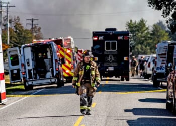 A firefighter walks down the street near the Church of Jesus Christ of Latter-day Saints that was attacked on Sept. 28, 2025 in Grand Blanc, Michigan.