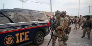 Immigration and Customs Enforcement agents armed with less-lethal weapons gather outside an ICE processing center during a protest in Broadview, Illinois, on Sept. 19, 2025.