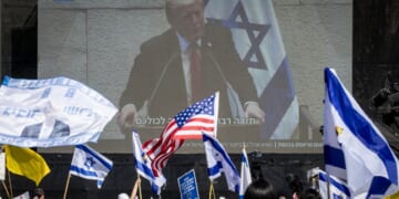 People watch President Donald Trump address the Knesset, Israel's parliament, on a giant screen in Hostages Square in Tel Aviv, Israel, on Monday.