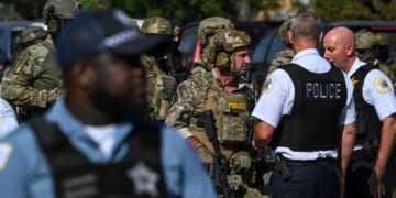 Chicago police officers speak with federal agents in Chicago, Illinois, on Oct. 4, 2025.