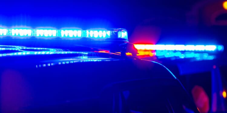 The blue and red police lights at a crime scene in a generic stock photograph.