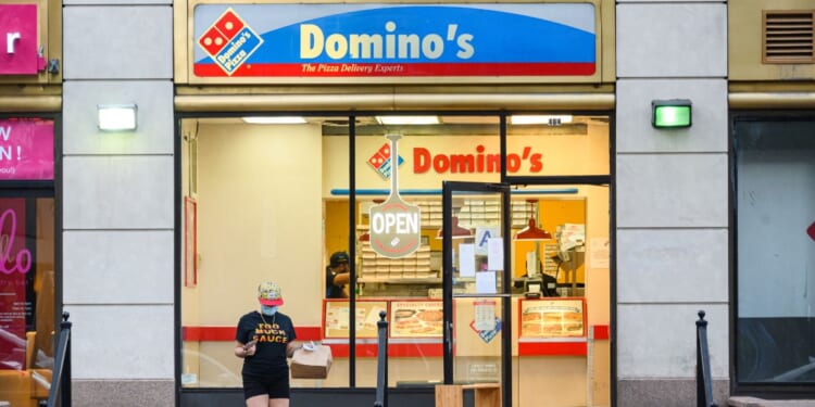 A person wears a protective face mask outside Domino's Pizza in Kips Bay as New York City on July 9, 2020.