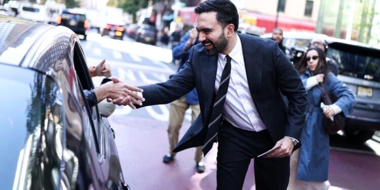 Democratic socialist candidate Zohran Mamdani greets people on the street Monday in the Manhattan borough of New York City during early voting for the upcoming mayoral election.