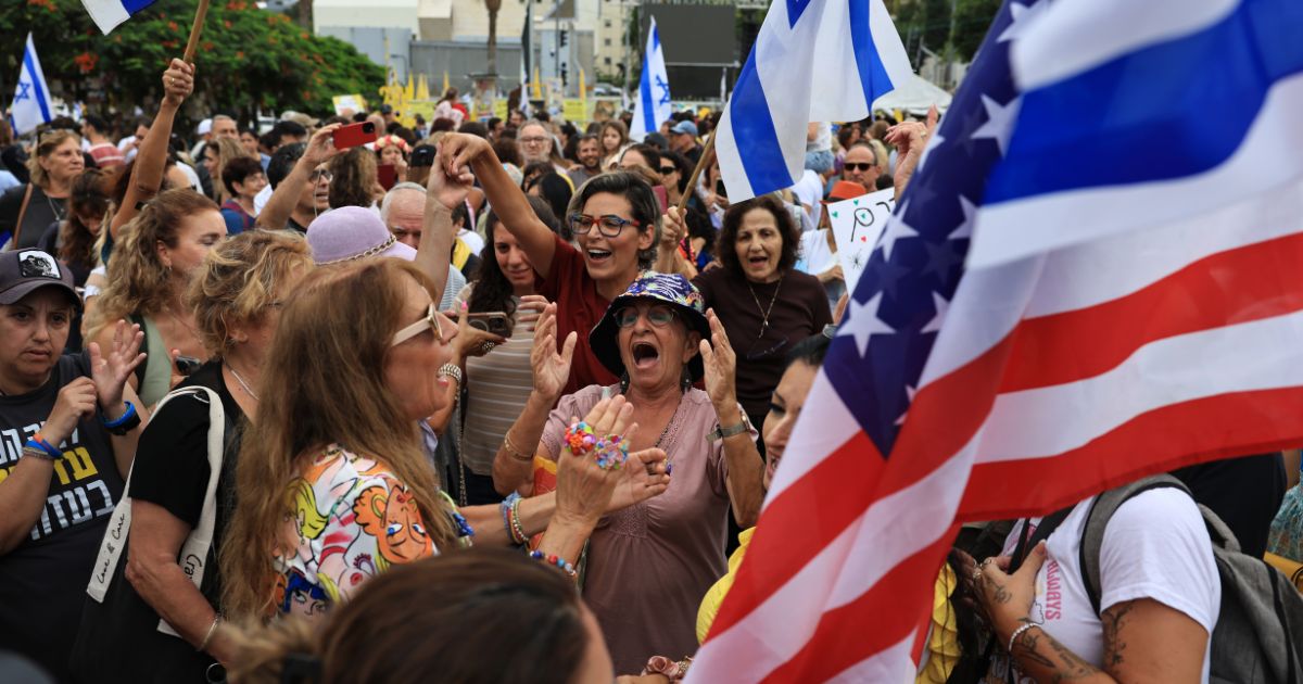 Israelis celebrate with Israeli and American flags as they react to the news of the Gaza peace deal at Hostages Square in Tel Aviv, Israel, on Thursday.