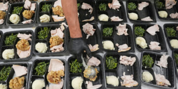A volunteer prepares meals Thursday at the Philabundance Community Kitchen in Philadelphia.