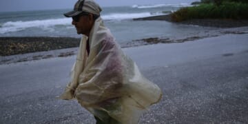 A man walks in the rain Tuesday before the arrival of Hurricane Melissa in Canizo, a community in Santiago de Cuba.