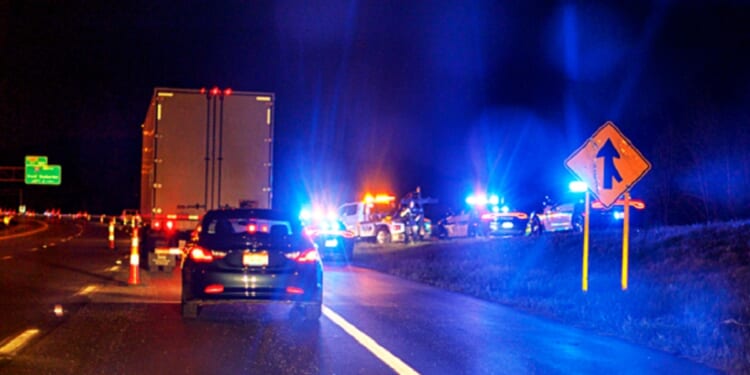 A stock photo shows a highway scene at night with emergency vehicles responding to an accident.