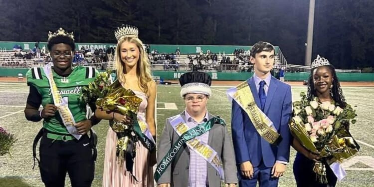 Trey Smith, left, star quarterback at Roswell High School in Roswell, Georgia, gave his homecoming king crown to Jake Jeffries, center, described as "a devoted senior with Down syndrome who is the team’s biggest fan and longtime helper with the training staff."