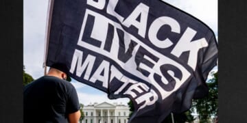 A man carries a Black Lives Matter flag in Lafayette Square outside the White House in a file photo from Aug. 27, 2020.