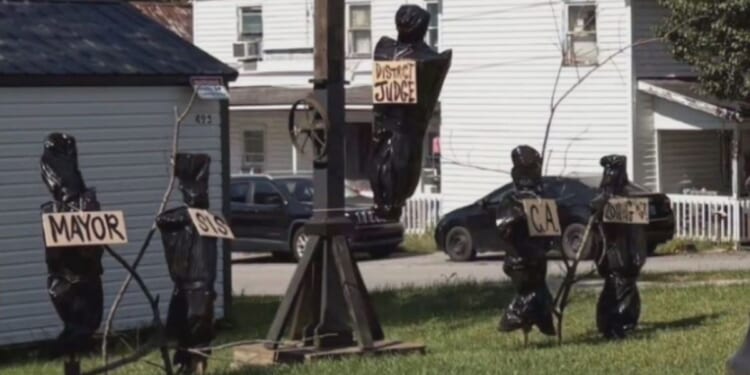 The display featured a gallows and several body bags with signs depicting the titles of local government officials.