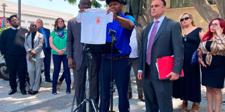Jonathan Wright, 39, holds up the T-shirt he was given when he first went to MacLaren Children's Center in El Monte as an 8-year-old during a news conference in Los Angeles on June 9, 2022.