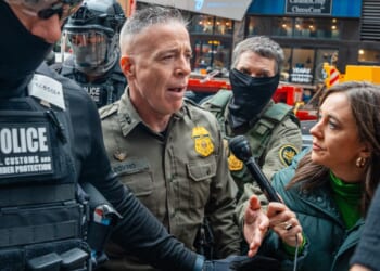 Border Patrol commander Gregory Bovino pushes through a crowd of media and protesters as he enters the Dirksen Federal Building Tuesday in Chicago, Illinois.
