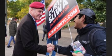 New York City mayoral candidate Curtis Sliwa, left, shakes hands with a volunteer Tuesday in the Queens borough of New York