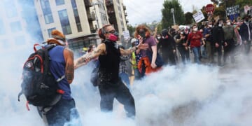 Federal agents, including members of the Department of Homeland Security, the Border Patrol, and police, clash with protesters outside a downtown U.S. Immigration and Customs Enforcement facility Saturday in Portland, Oregon.