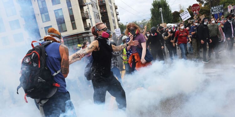 Federal agents, including members of the Department of Homeland Security, the Border Patrol, and police, clash with protesters outside a downtown U.S. Immigration and Customs Enforcement facility Saturday in Portland, Oregon.