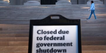 A woman walks past a sign indicating the National Gallery of Art in Washington, D.C., is closed Oct. 6 as the U.S. government continues its shutdown.