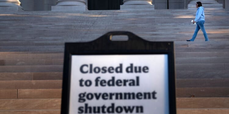 A woman walks past a sign indicating the National Gallery of Art in Washington, D.C., is closed Oct. 6 as the U.S. government continues its shutdown.