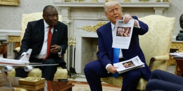President Donald Trump holds up a printed article from "American Thinker" while accusing South Africa President Cyril Ramaphosa of state-sanctioned violence against white farmers in South Africa during a press availability in the Oval Office at the White House on May 21, 2025, in Washington, D.C.