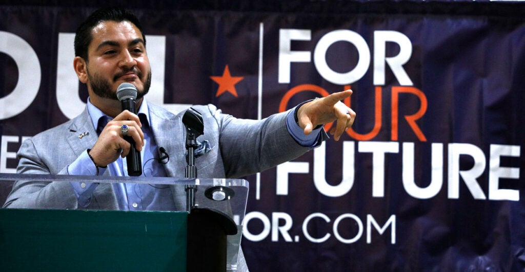 Abdul El-Sayed, dressed in a suit, speaks at a campaign event.
