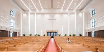 A woman prays inside a church.