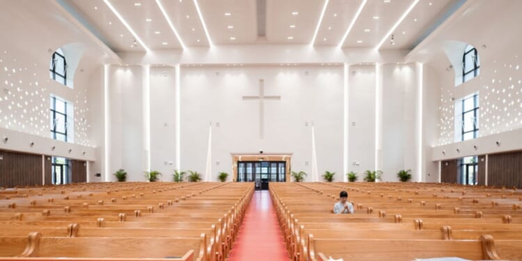 A woman prays inside a church.