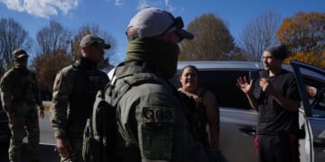 Department of Homeland Security Investigations officers question an individual after two people fled the scene while being stopped for selling flowers on the side of the road on Nov. 16, 2025, in Charlotte, North Carolina.