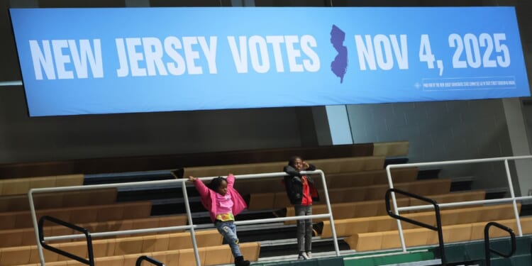 Children stand under a voting banner as they attend a New Jersey Democratic gubernatorial candidate Mikie Sherrill Get Out the Vote Rally at Essex County College Gymnasium on Nov. 1, 2025, in Newark, New Jersey.