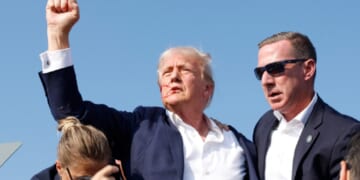 Now-President Donald Trump raises his right fist high as he is rushed offstage after an assassination attempt July 13, 2024, in Butler, Pennsylvania.