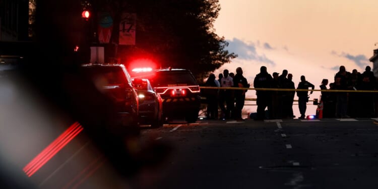 Law enforcement officials gather near the site where to National Guardsmen were shot, one fatally, in Washington, DC on Nov. 26, 2025.