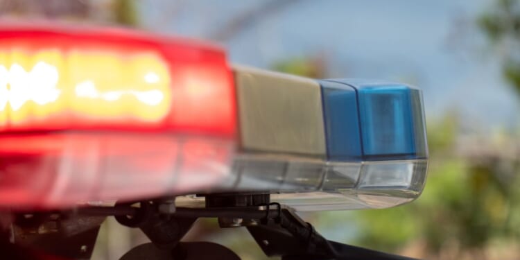 Emergency lights on a police vehicle flash.