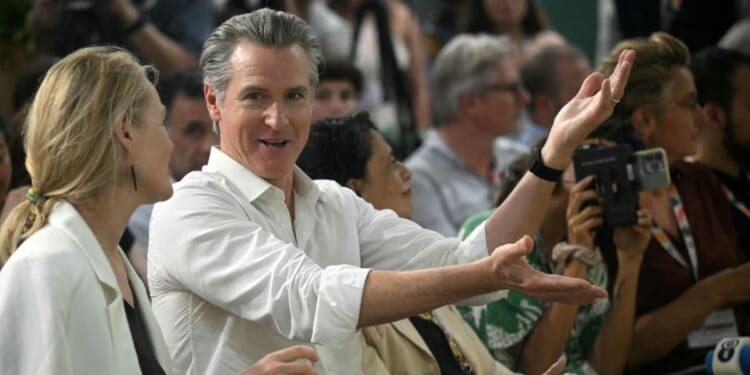 The Governor of California Gavin Newsom speaks with a woman during the COP30 UN Climate Change Conference, in Belem, Para State, Brazil, on November 11, 2025.