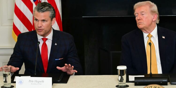 President Donald Trump listens to Defense Secretary Pete Hegseth during a law enforcement roundtable in the State Dining Room of the White House on Oct. 23, 2025, in Washington, D.C.