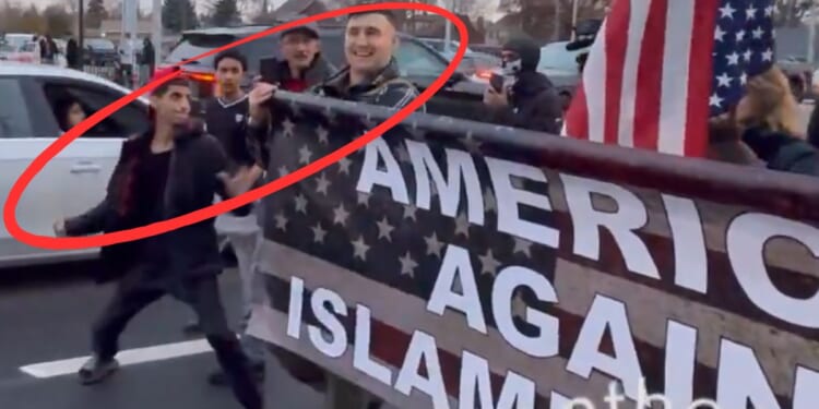 The young man winds up to hit Jake Lang during the "Americans Against Islamification" march in Dearborn, Michigan.