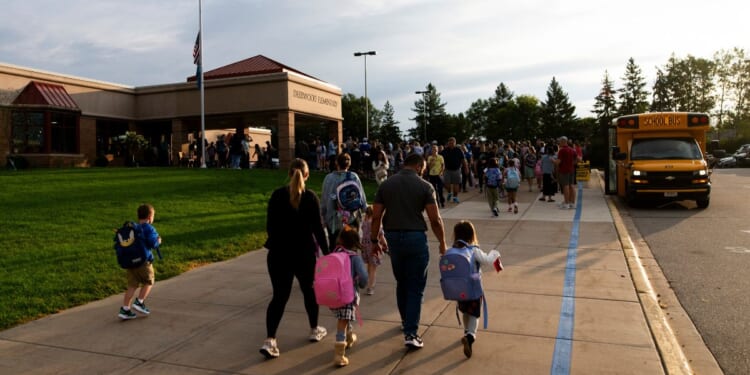 Parents drop off their children for the first day of school at Deerwood Elementary on Sept. 2, 2025, in Eagan, Minnesota.