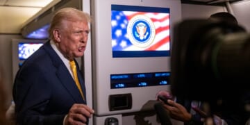 President Donald Trump speaks to reporters aboard Air Force One on Friday while in flight from Washington to West Palm Beach International Airport.