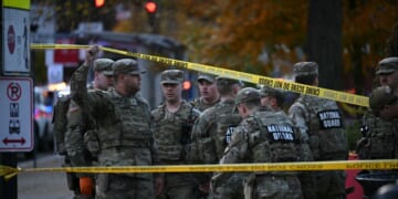 National Guard soldiers stand behind the crime scene tape at a corner in downtown Washington, D.C., on Nov. 26, 2025.