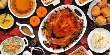 A traditional turkey Thanksgiving dinner is set up on a table.