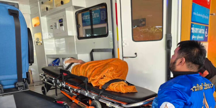 An emergency rescue team transports a woman discovered to be alive Sunday after being transported to a cremation facility at a Buddhist temple in Nonthaburi province, Thailand.