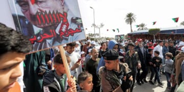 A youth hols up a sign at a protest in the coastal Libyan city of Tajura on Feb. 25, 2022.