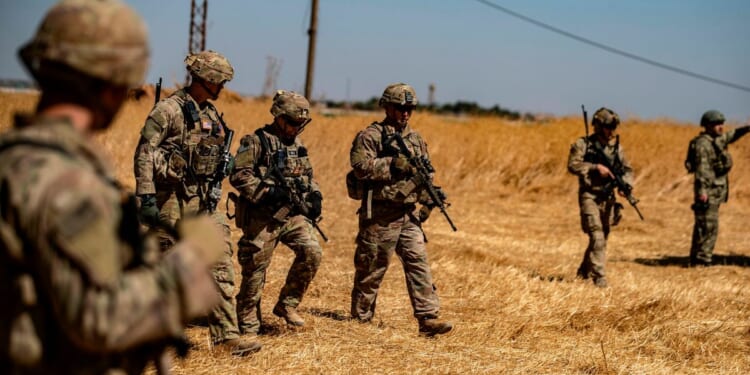 US soldiers walk with Turkish troops in the Syrian village of al-Hashisha on Sept. 8, 2019.