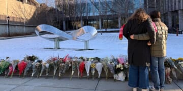 Senior Zoe Kass and her boyfriend leave flowers Dec. 16 at the engineering building at Brown University in Providence, Rhode Island. They fled the building Dec. 13 when a shooter opened fire during a finals study session.